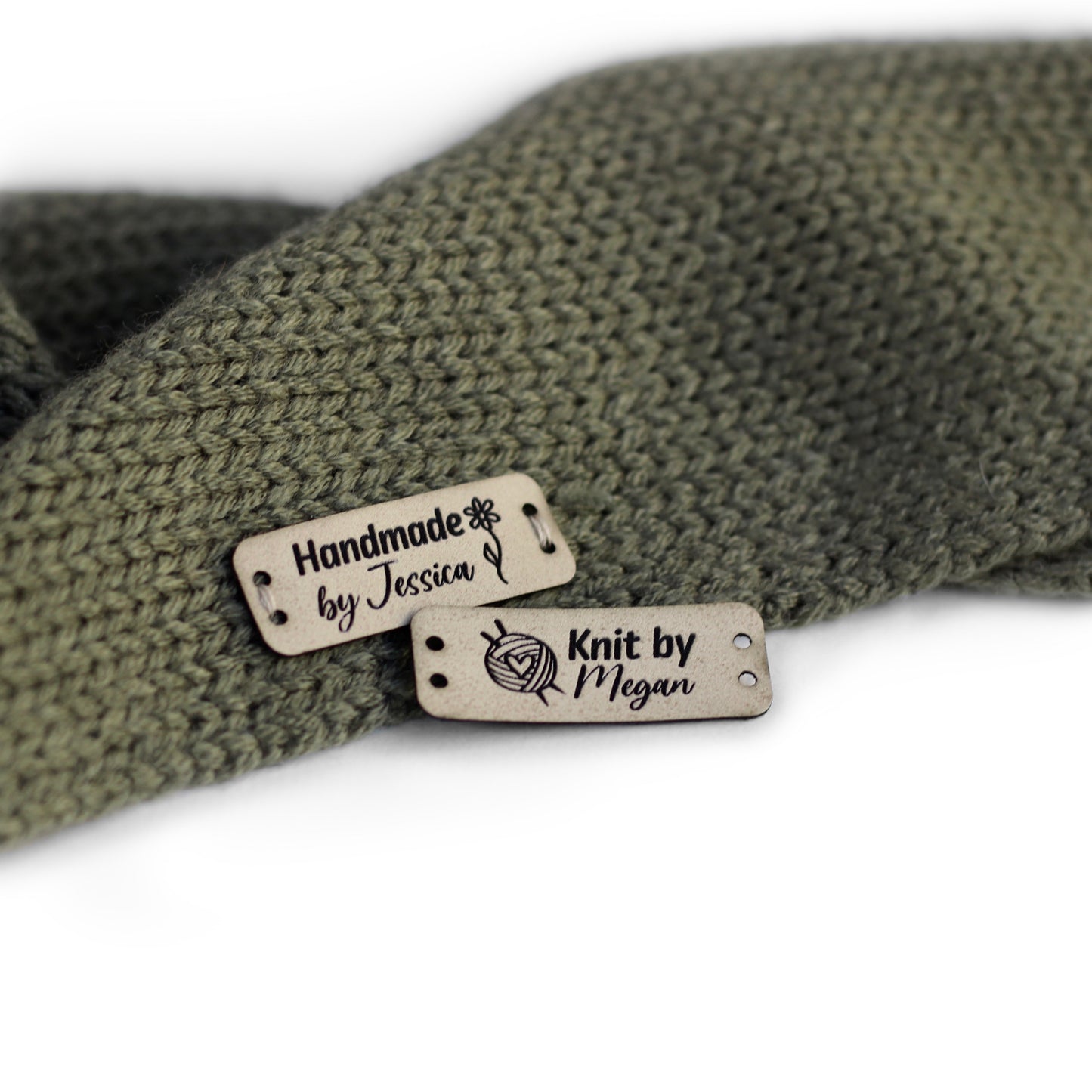 Personalized knitting leather tag in ivory, hand sewn on a knitted fabric.