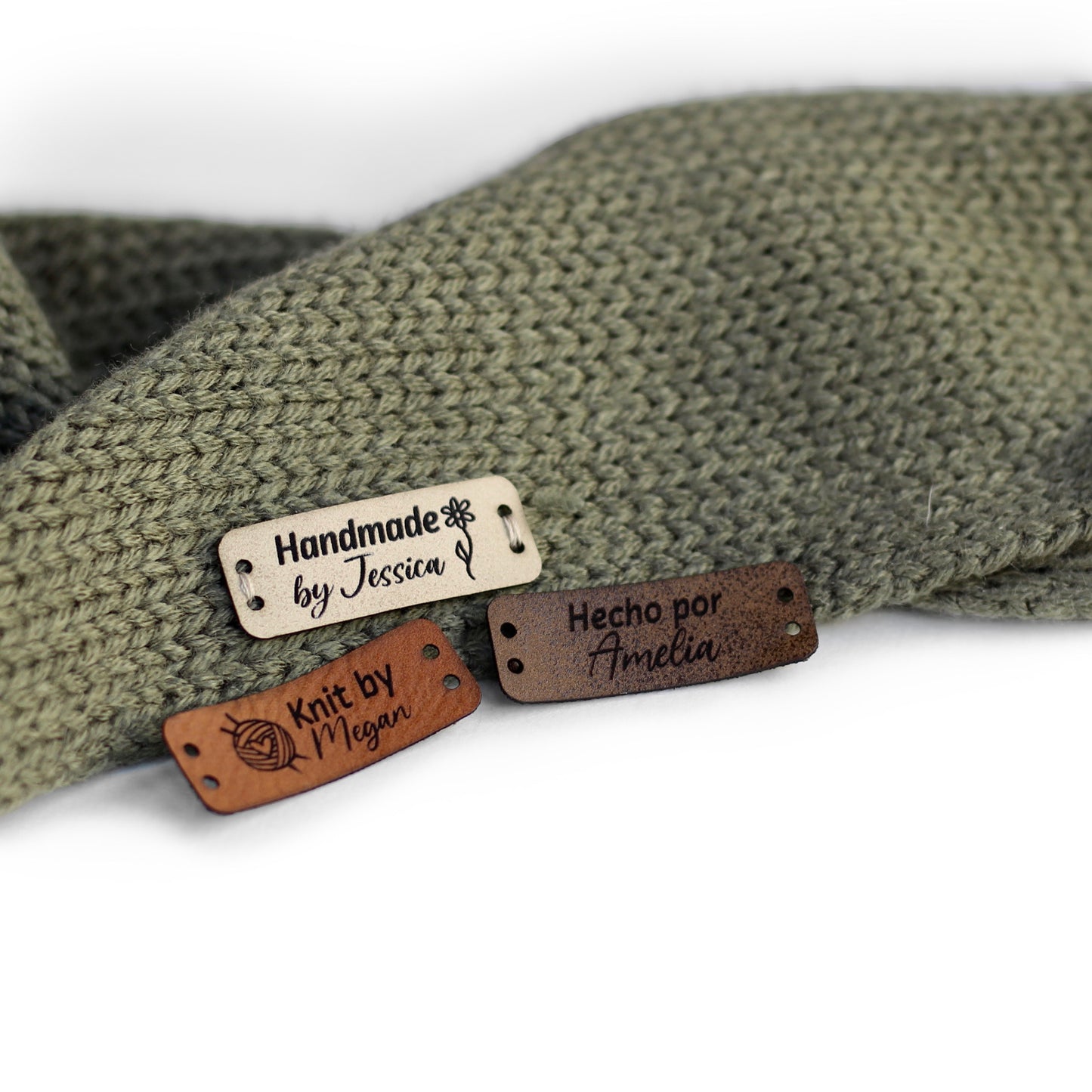 Personalized knitting leather tag in a mix of ivory, brick, and coffee hand sewn on a knitted fabric.