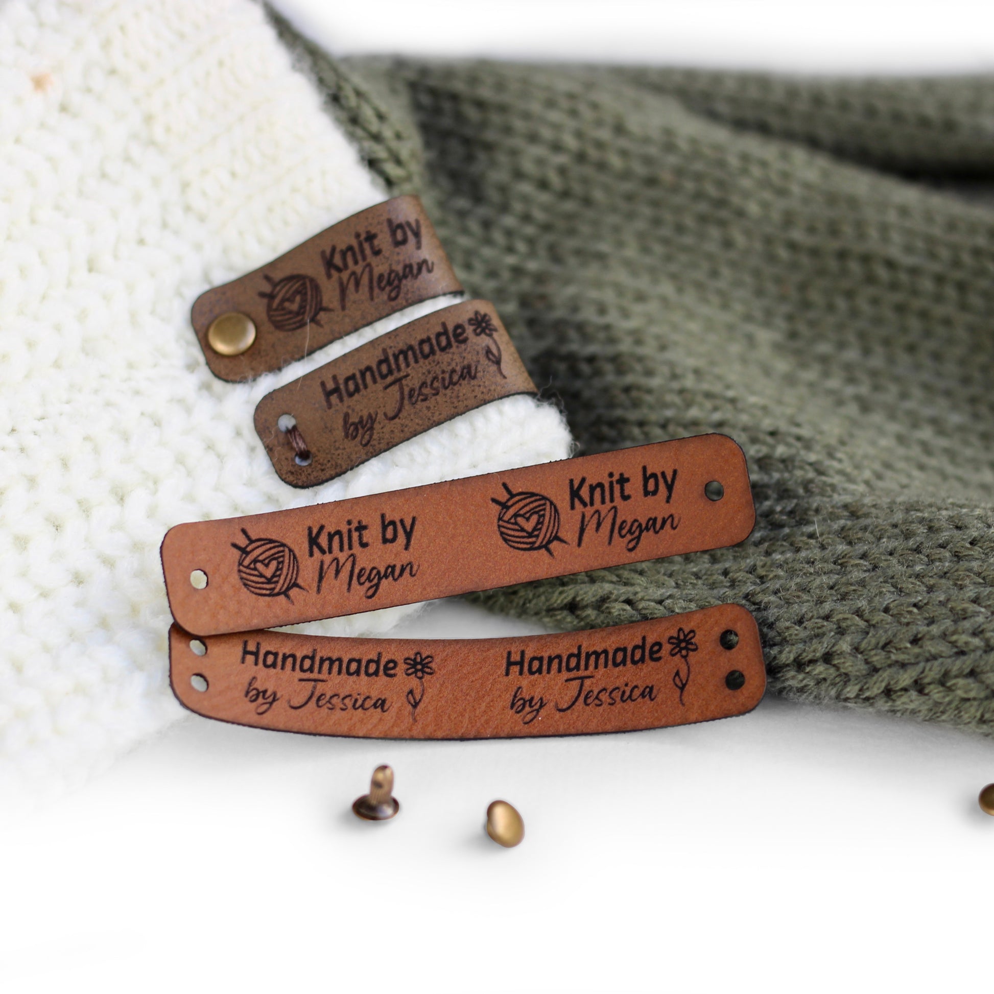 Folded tags attached to a knitted fabric with bronze rivets in brick faux leather