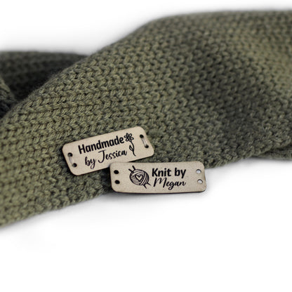 Personalized knitting leather tag in ivory, hand sewn on a knitted fabric.
