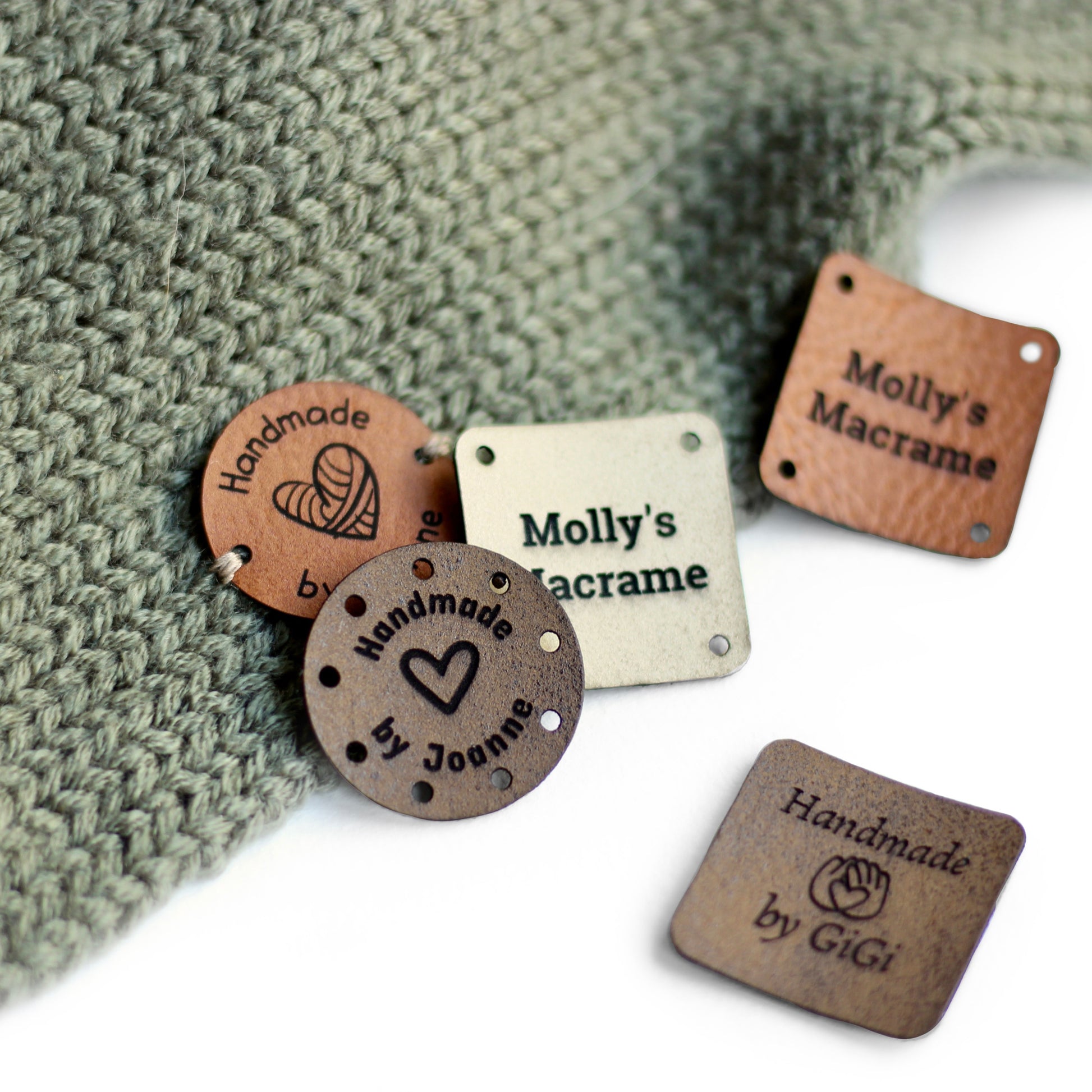 Faux leather tags in ivory, brick, and coffee on a knitted item.