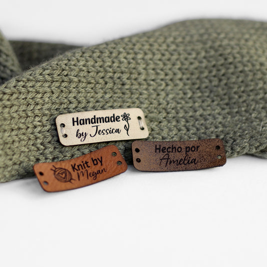 Personalized knitting leather tag in a mix of ivory, brick, and coffee hand sewn on a knitted fabric.
